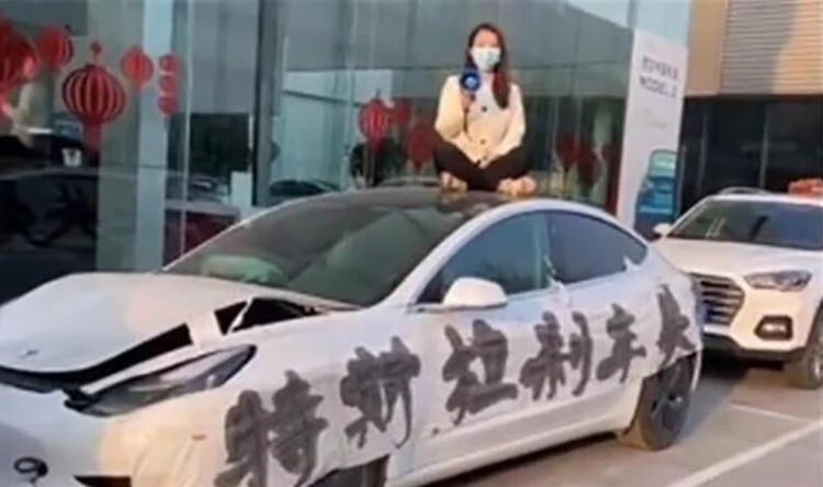 该听谁的？她为什么要坐在特斯拉车顶维权？